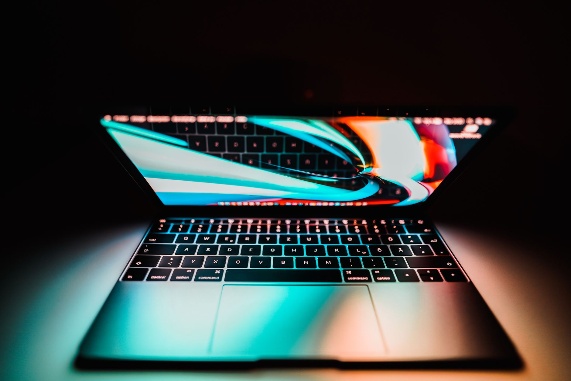close-up of a modern laptop with a vibrant screen in low light